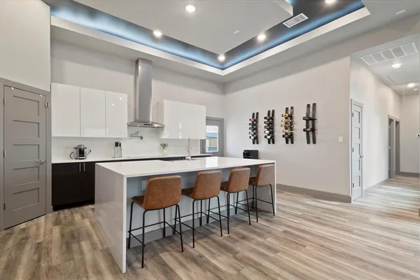 a kitchen with stainless steel appliances granite countertop a table chairs sink and cabinets