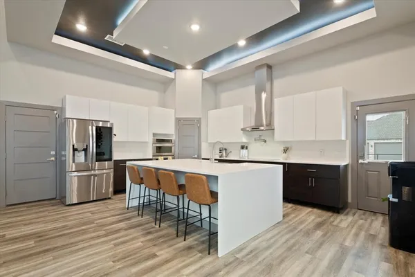 a large kitchen with stainless steel appliances a sink and cabinets