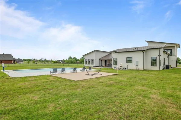 a front view of a house with swimming pool and yard