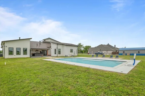 a house view with swimming pool in front of it
