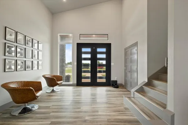 a view of an empty room with wooden floor and windows