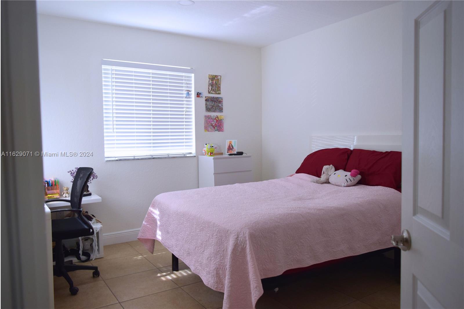 12844 Southwest 256th Terrace Homestead, FL 33032 - Photo 11 of 21 a bedroom with a bed and a table chair