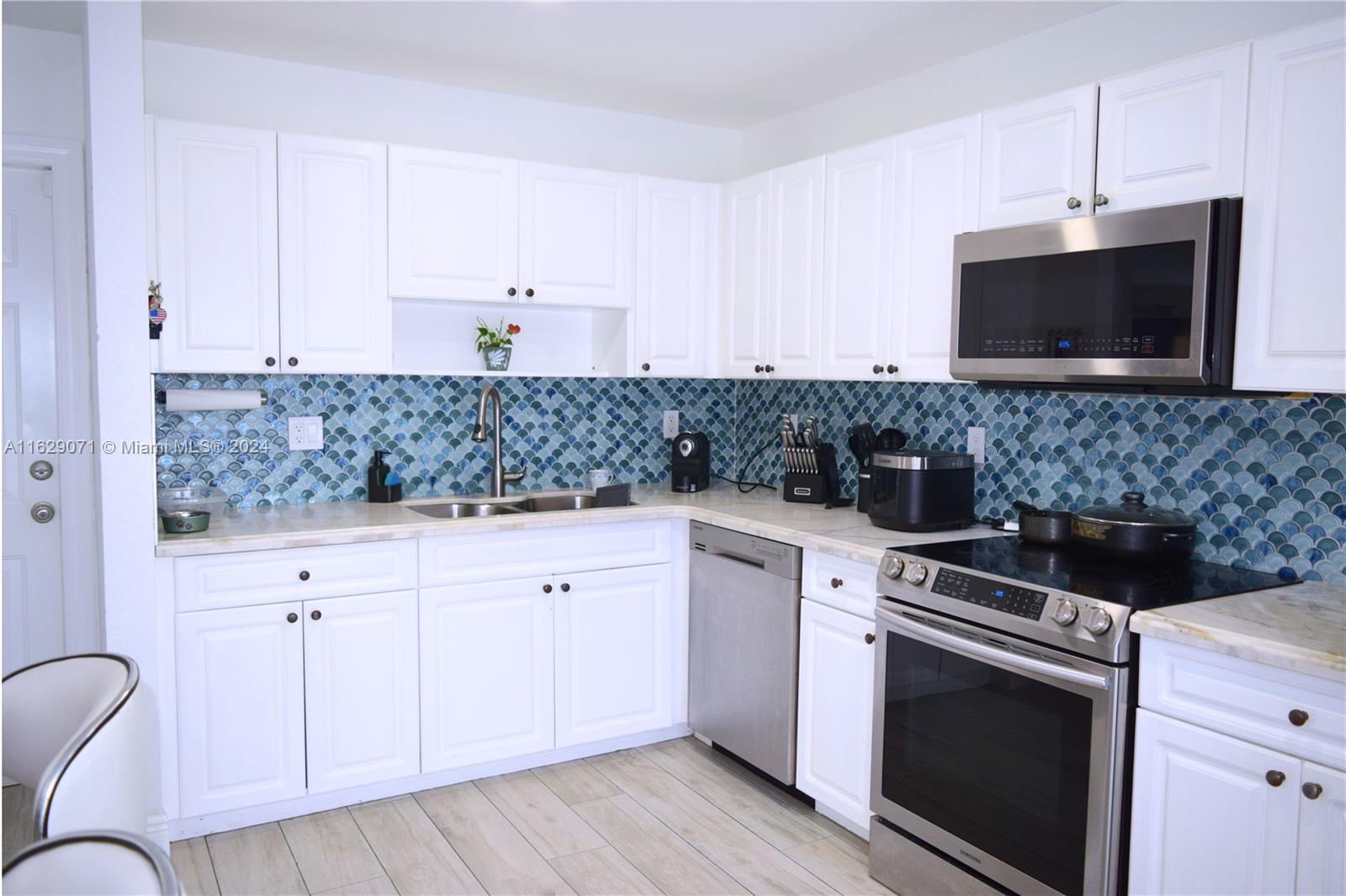 12844 Southwest 256th Terrace Homestead, FL 33032 - Photo 21 of 21 a kitchen with stainless steel appliances granite countertop a stove a sink and a microwave