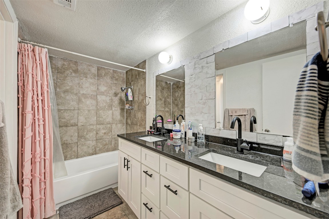 3102 Cedar Street, Unit A Austin, TX 78705 - Photo 13 of 23 a bathroom with a double vanity sink and mirror with bathtub