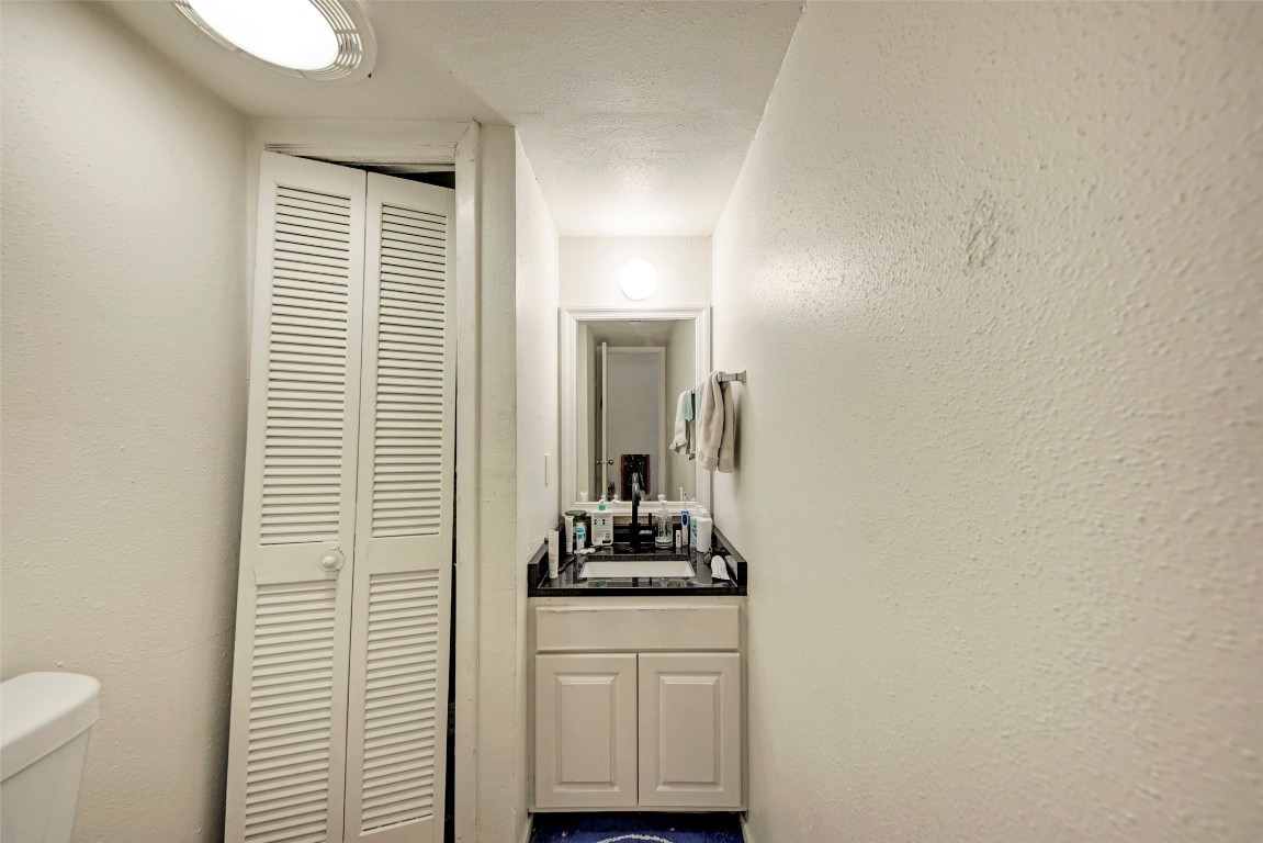 3102 Cedar Street, Unit A Austin, TX 78705 - Photo 9 of 23 a bathroom with a sink a toilet and mirror