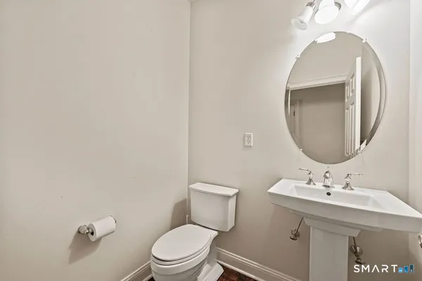 a bathroom with a toilet a sink and mirror