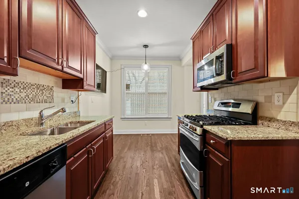 a kitchen with granite countertop stainless steel appliances and wooden cabinets