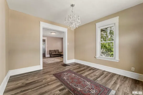 a view of a hallway view with wooden floor and a chandelier