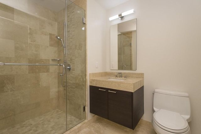 a bathroom with a granite countertop sink toilet and shower