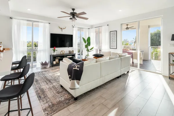 a living room with furniture a flat screen tv and a large window