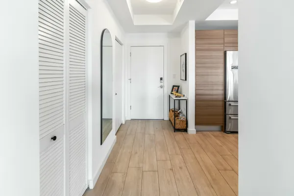 a view of a hallway with wooden floor and staircase
