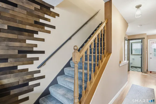 a view of staircase with lots of frames on wall and a large window
