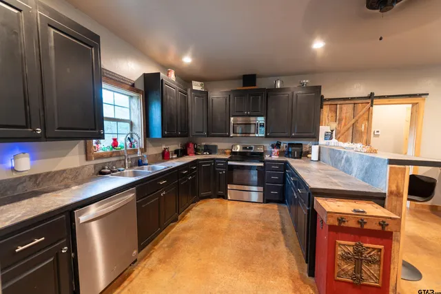 a kitchen with stainless steel appliances granite countertop a stove sink and cabinets