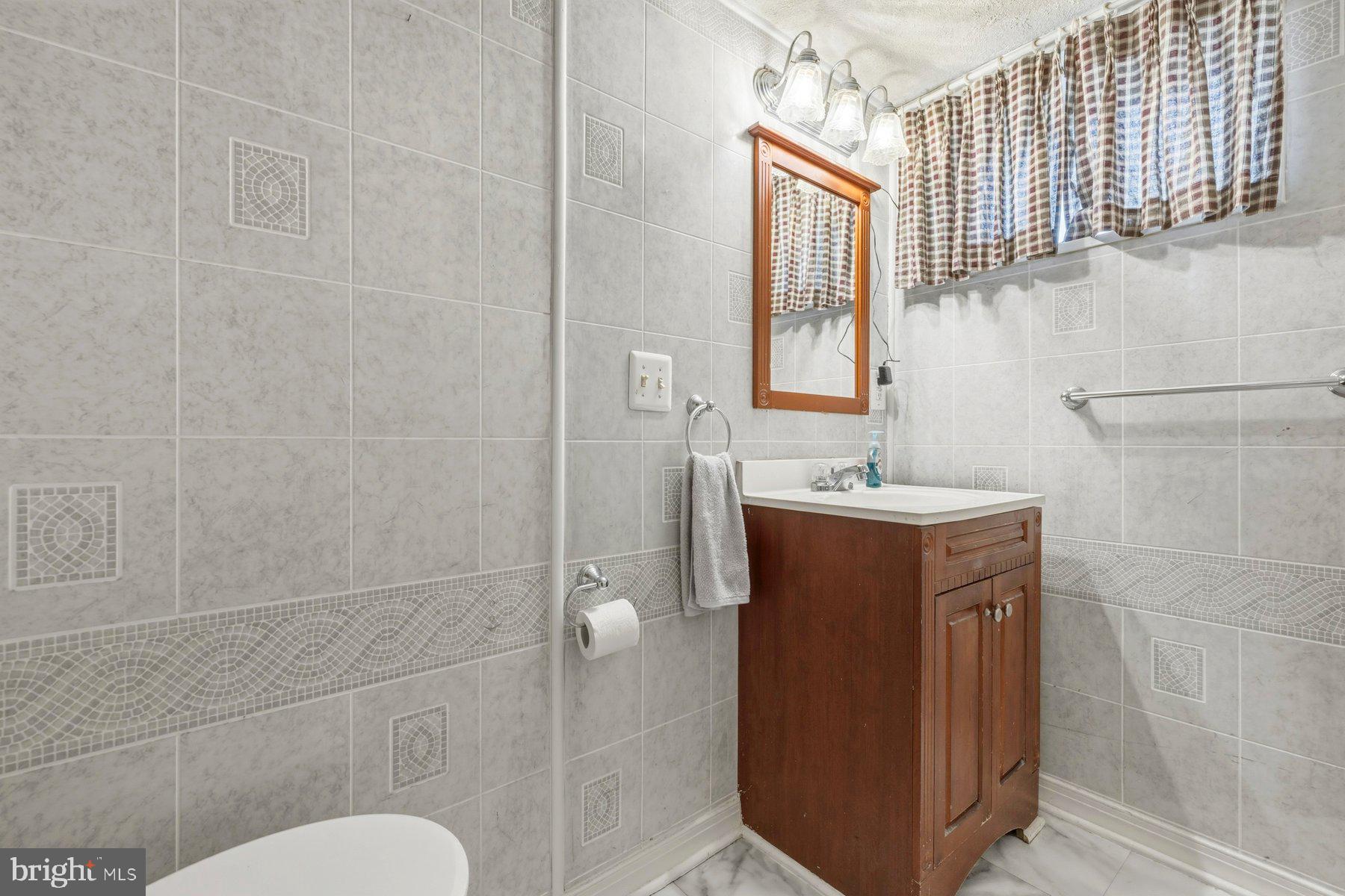 1003 Lee Road Glen Burnie, MD 21061 - Photo 26 of 44 a bathroom with a sink mirror vanity and toilet