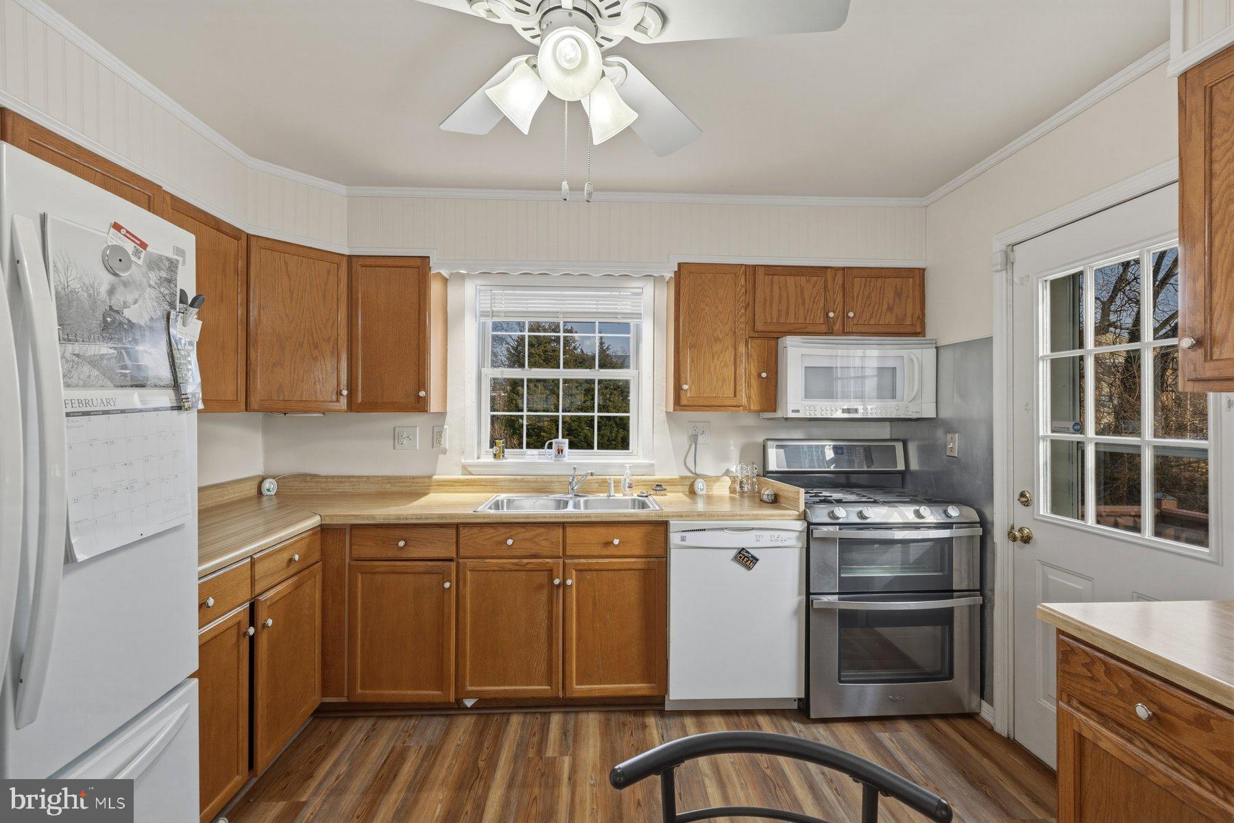 1003 Lee Road Glen Burnie, MD 21061 - Photo 4 of 44 a kitchen with a stove a sink and wooden cabinets