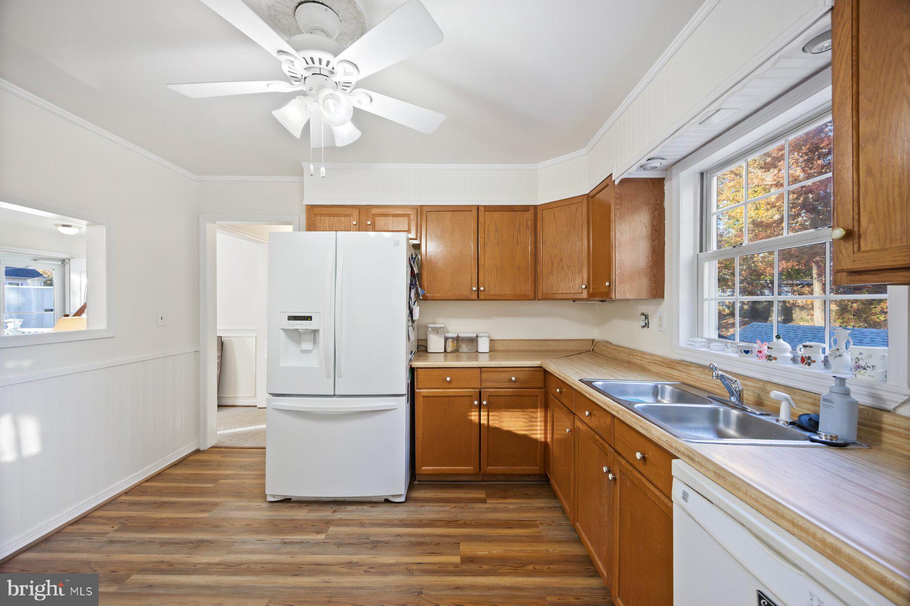 1003 Lee Road Glen Burnie, MD 21061 - Photo 7 of 44 a kitchen with stainless steel appliances granite countertop a refrigerator a stove a sink and a refrigerator with wooden floors