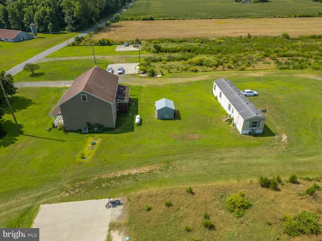 a view of a house with a big yard and potted plants