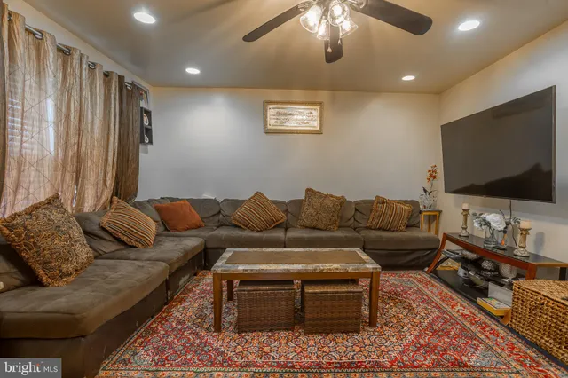 a living room with furniture kitchen view and a flat screen tv