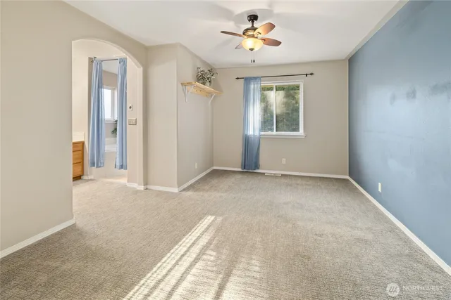 a view of a big room with windows and chandelier fan