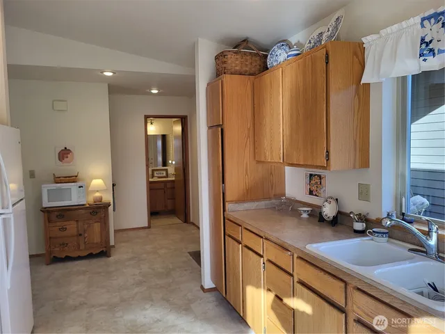 a living room with furniture kitchen view and large windows