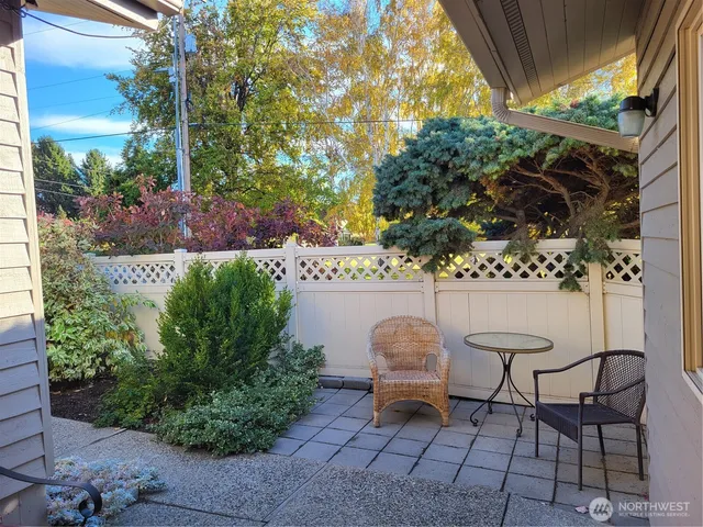 a backyard with table and chairs and potted plants