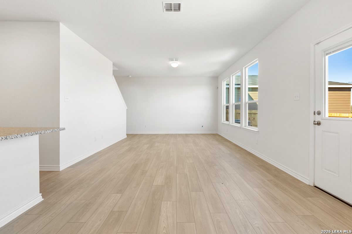 10045 Jagger Avenue Converse, TX 78109 - Photo 9 of 28 an empty room with wooden floor and windows