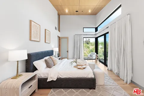 a bedroom with a large bed and a large window