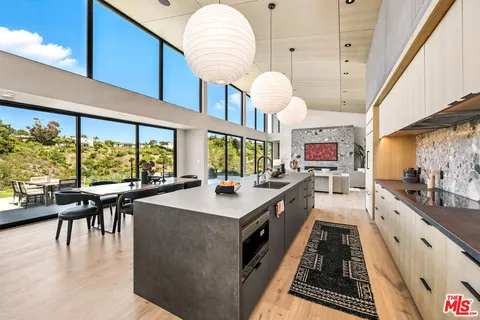 a large white kitchen with lots of counter space and a wooden floors