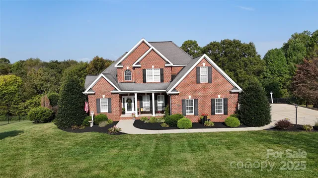 a front view of a house with a yard and trees