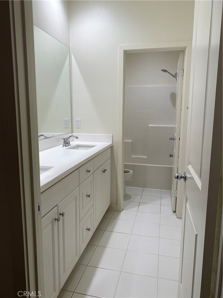 4232 West Ivesbrook Street Lancaster, CA 93536 - Photo 23 of 33 a bathroom with a granite countertop sink a toilet and a mirror