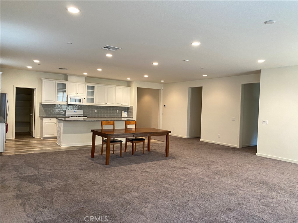 4232 West Ivesbrook Street Lancaster, CA 93536 - Photo 3 of 33 a view of kitchen with kitchen island stainless steel appliances refrigerator stove dining table and chairs