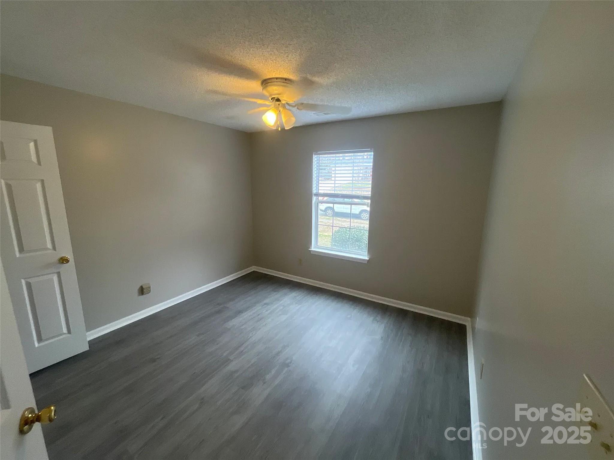 12042 Mallard Ridge Drive Charlotte, NC 28269 - Photo 16 of 19 an empty room with wooden floor and windows