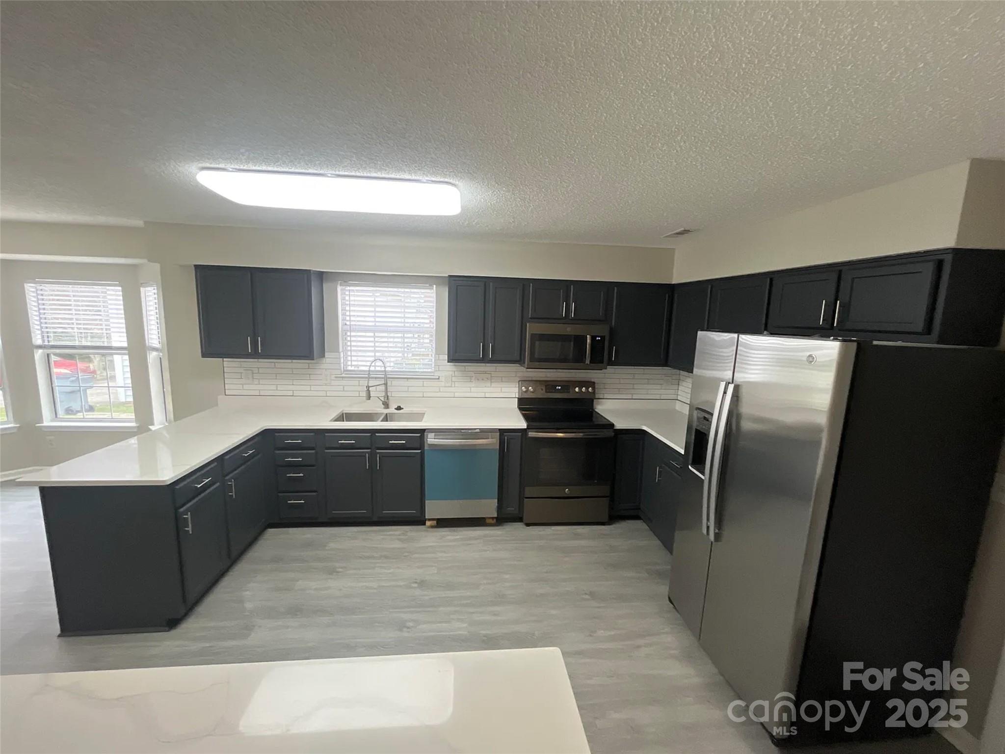 12042 Mallard Ridge Drive Charlotte, NC 28269 - Photo 4 of 19 a large kitchen with granite countertop a refrigerator and a sink