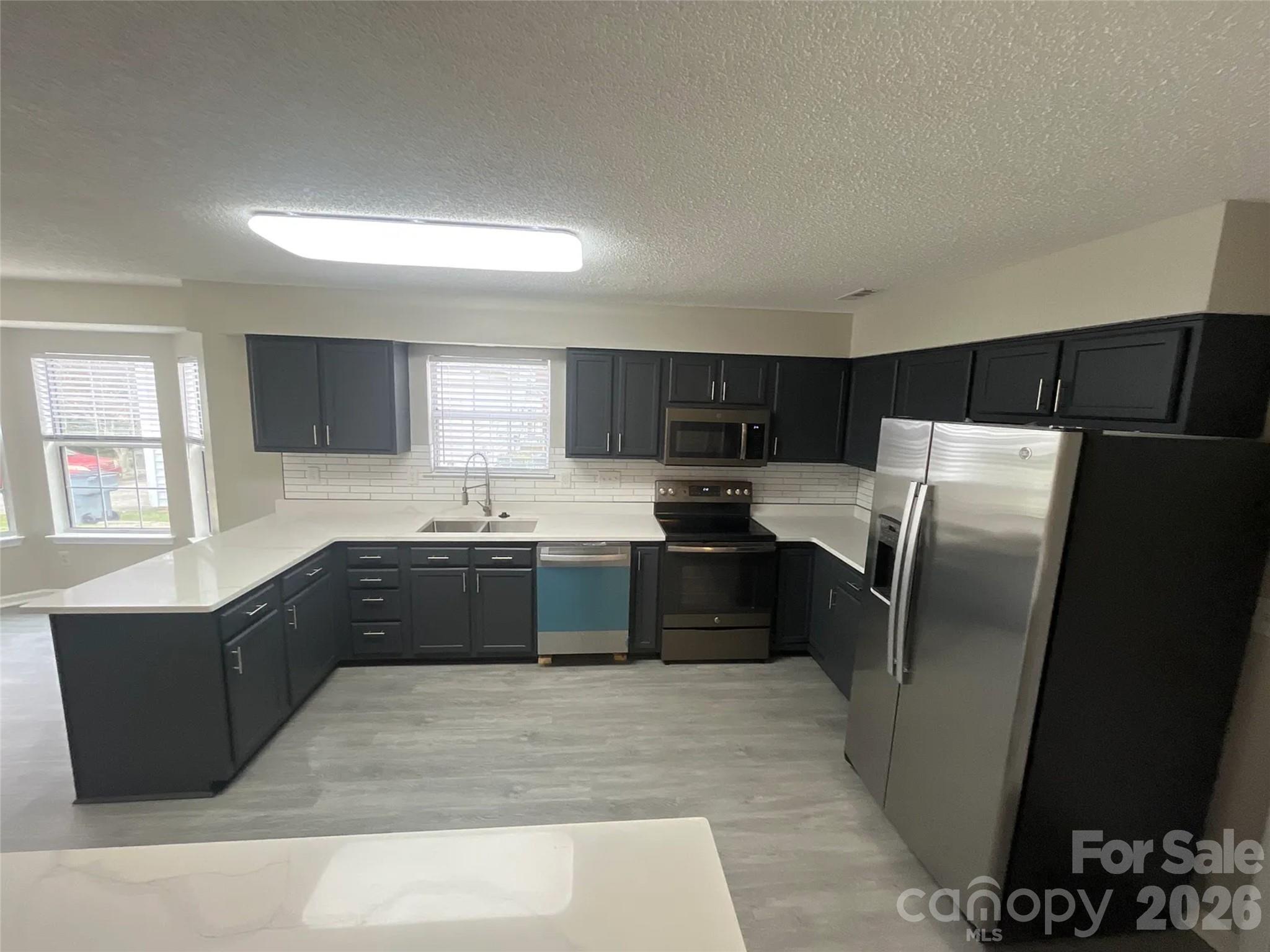 12042 Mallard Ridge Drive Charlotte, NC 28269 - Photo 4 of 20 a large kitchen with granite countertop a refrigerator and a sink