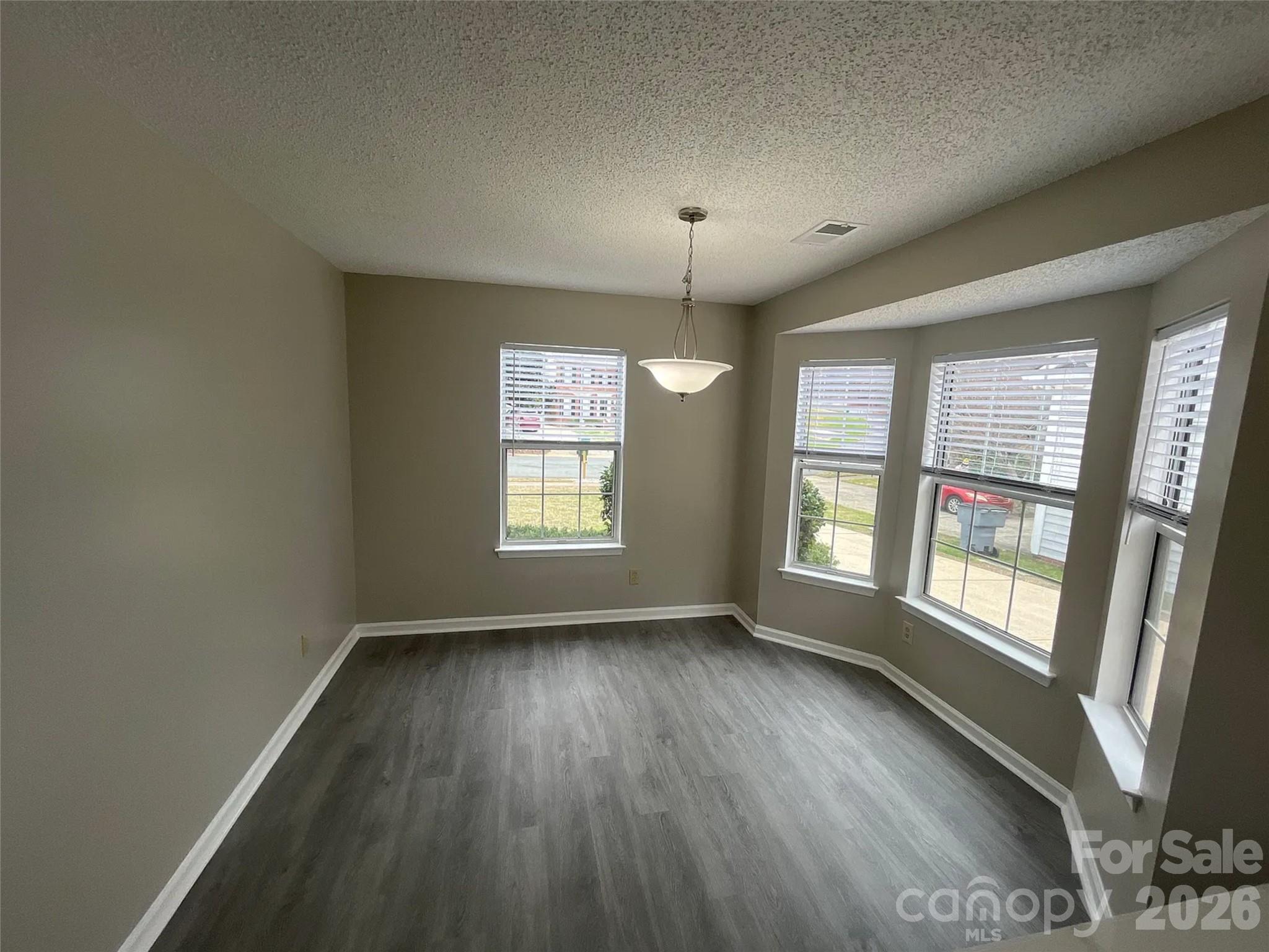12042 Mallard Ridge Drive Charlotte, NC 28269 - Photo 7 of 20 a view of an empty room with wooden floor and a window