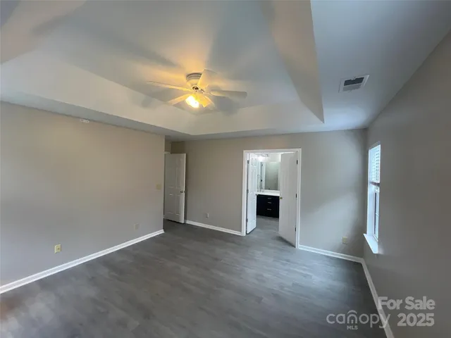an empty room with windows and fireplace