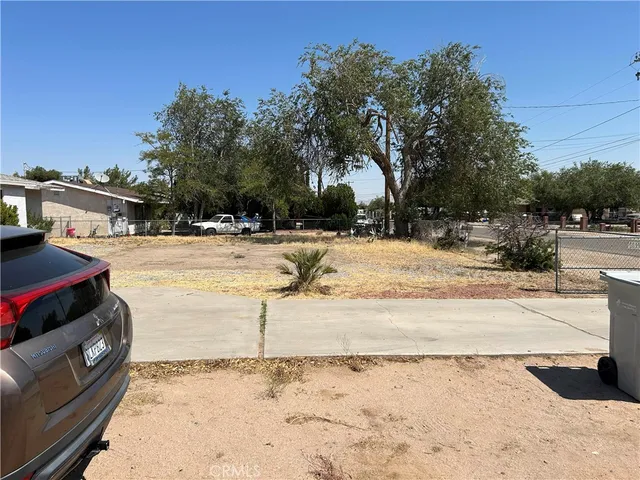 a view of a parking space with lots of trees in the background