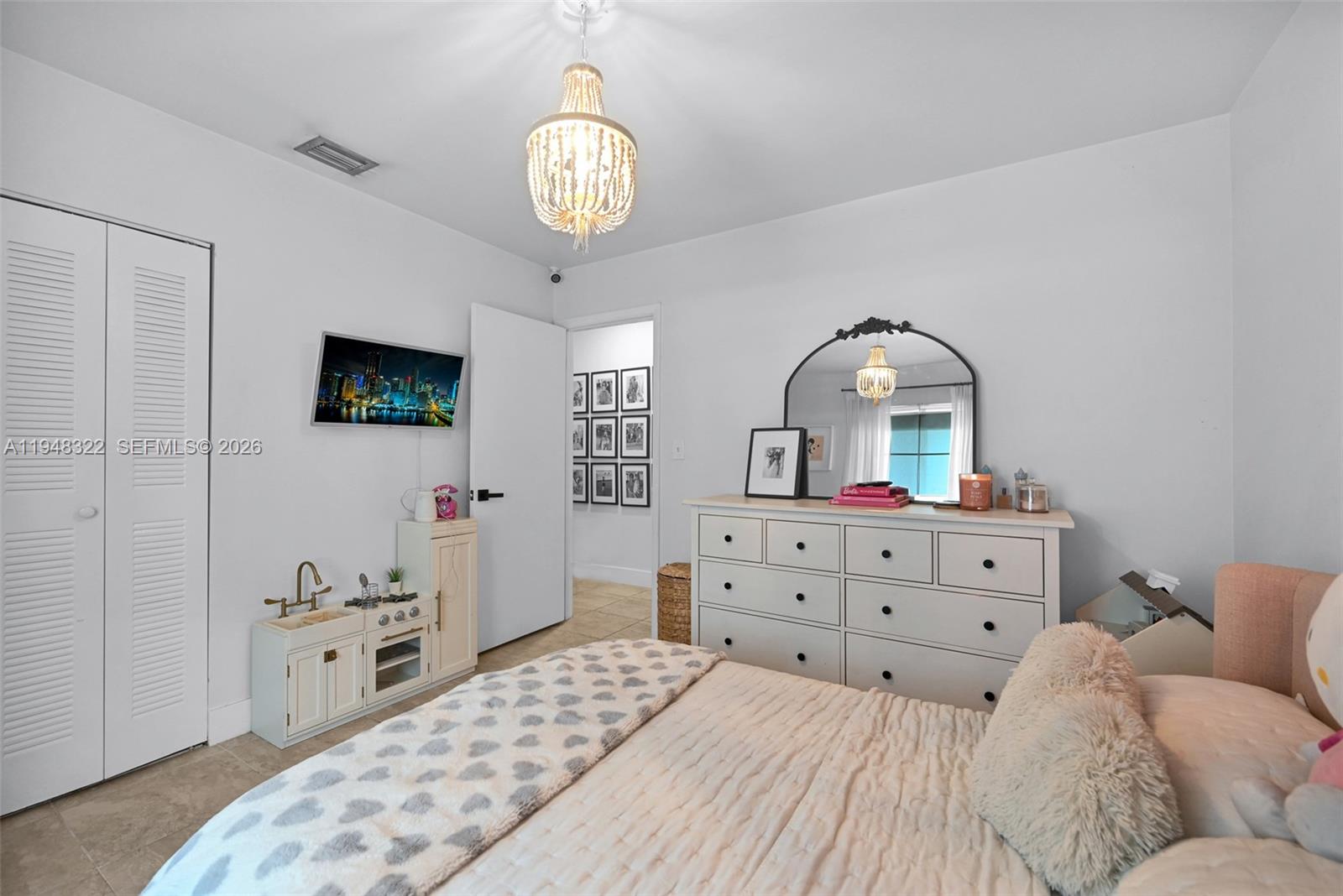 8780 Southwest 200th Terrace Cutler Bay, FL 33189 - Photo 21 of 39 a bedroom with a bed and a chandelier