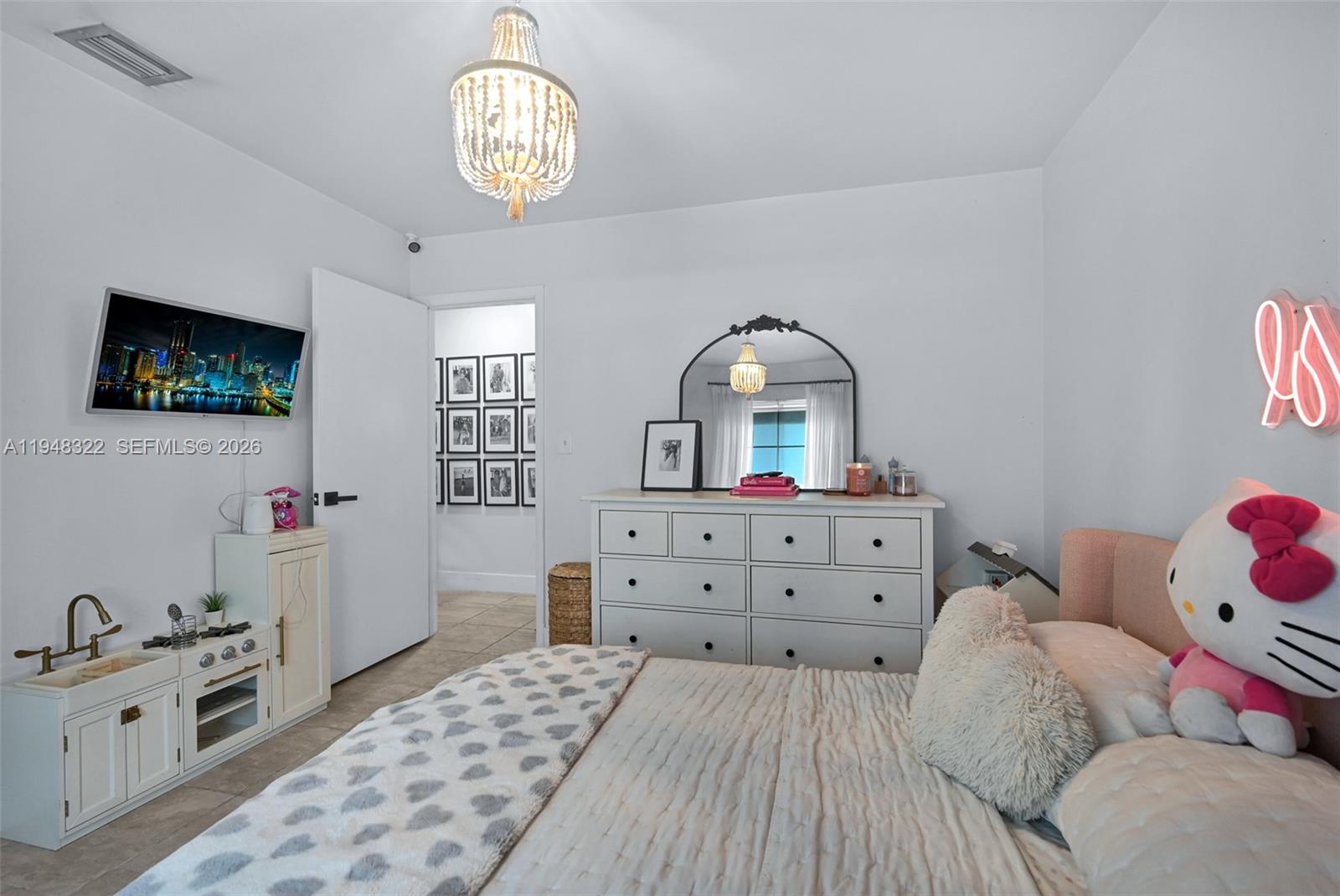 8780 Southwest 200th Terrace Cutler Bay, FL 33189 - Photo 22 of 39 a bedroom with a bed and a chandelier