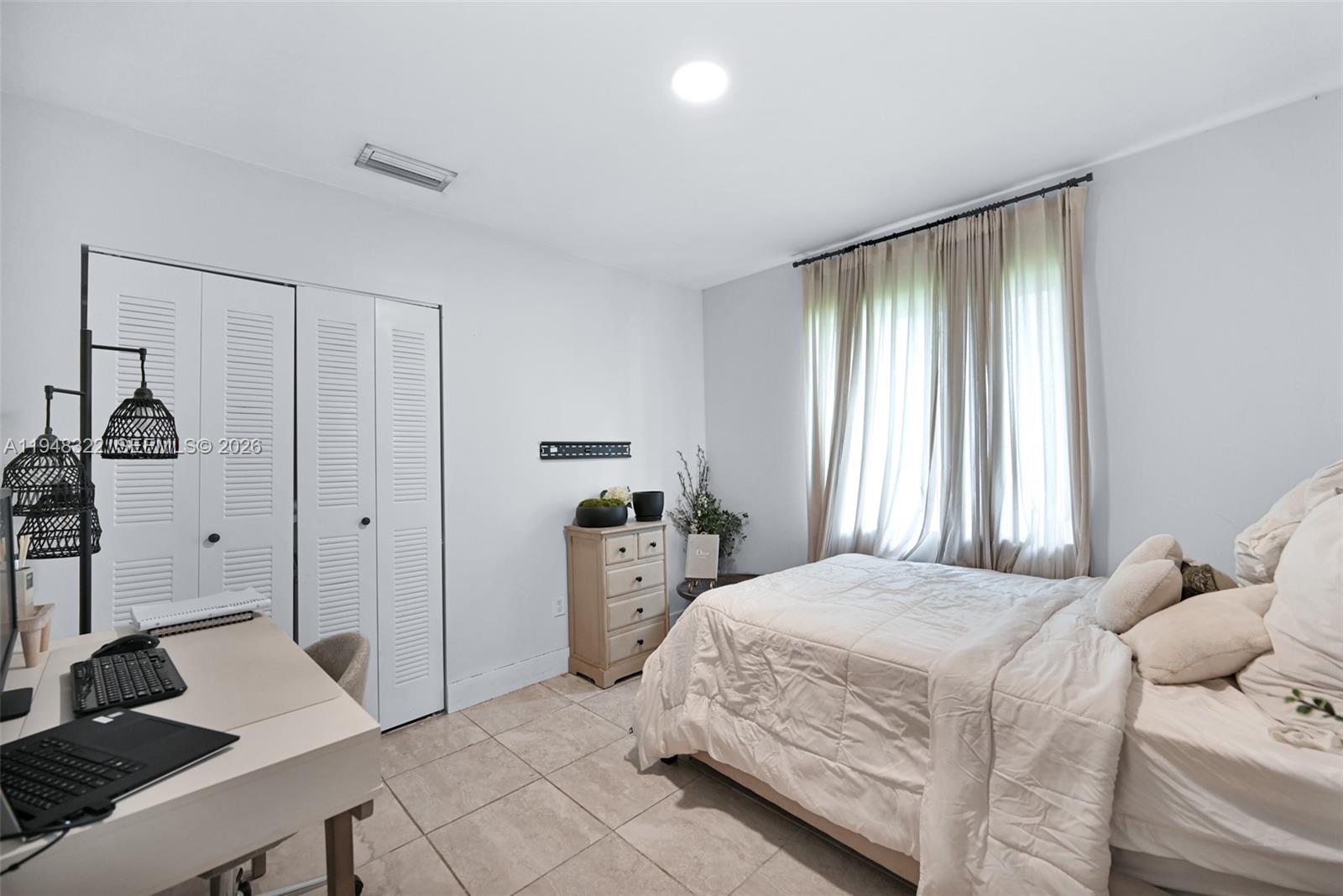 8780 Southwest 200th Terrace Cutler Bay, FL 33189 - Photo 30 of 39 a bedroom with a bed and a window