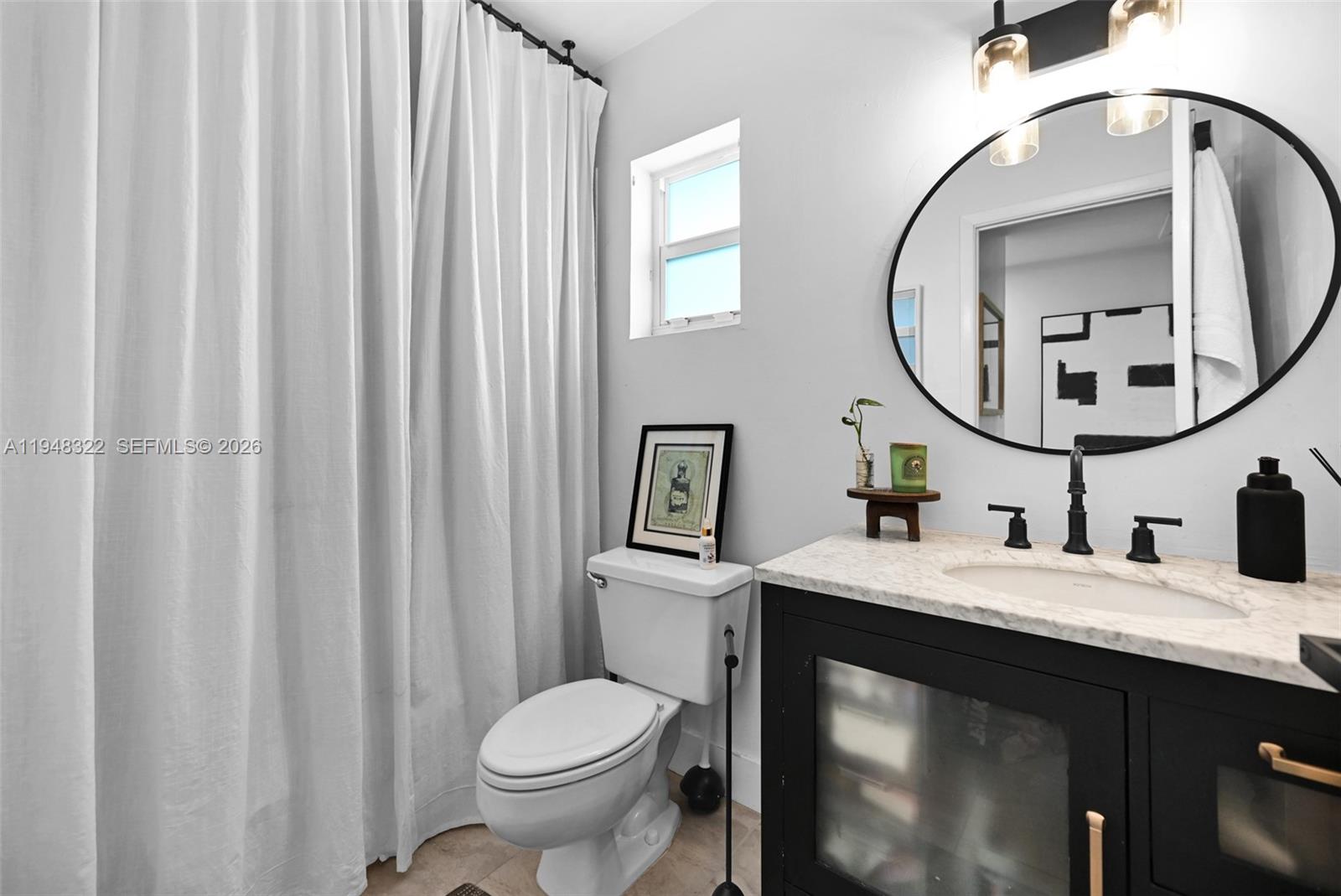 8780 Southwest 200th Terrace Cutler Bay, FL 33189 - Photo 31 of 39 a bathroom with a toilet a sink and a mirror