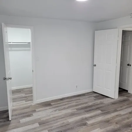a view of empty room with wooden floor