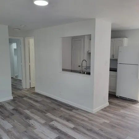 a view of an empty room with closet and a window