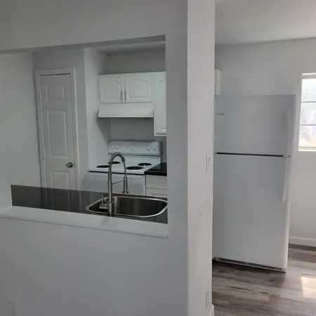 a kitchen with a refrigerator and a sink