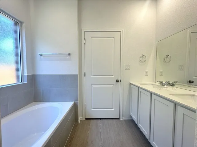 a bathroom with a tub sink and mirror