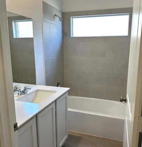 a bathroom with a tub sink and mirror