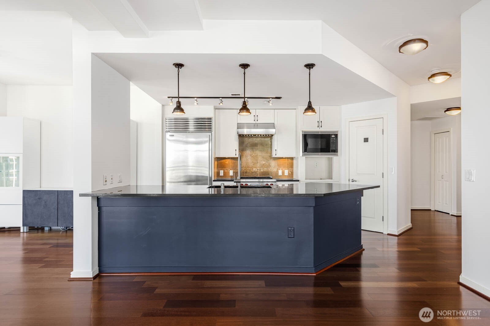819 Virginia Street, Unit 3303 Seattle, WA 98101 - Photo 3 of 29 a kitchen with stainless steel appliances granite countertop a sink a stove and a wooden floors