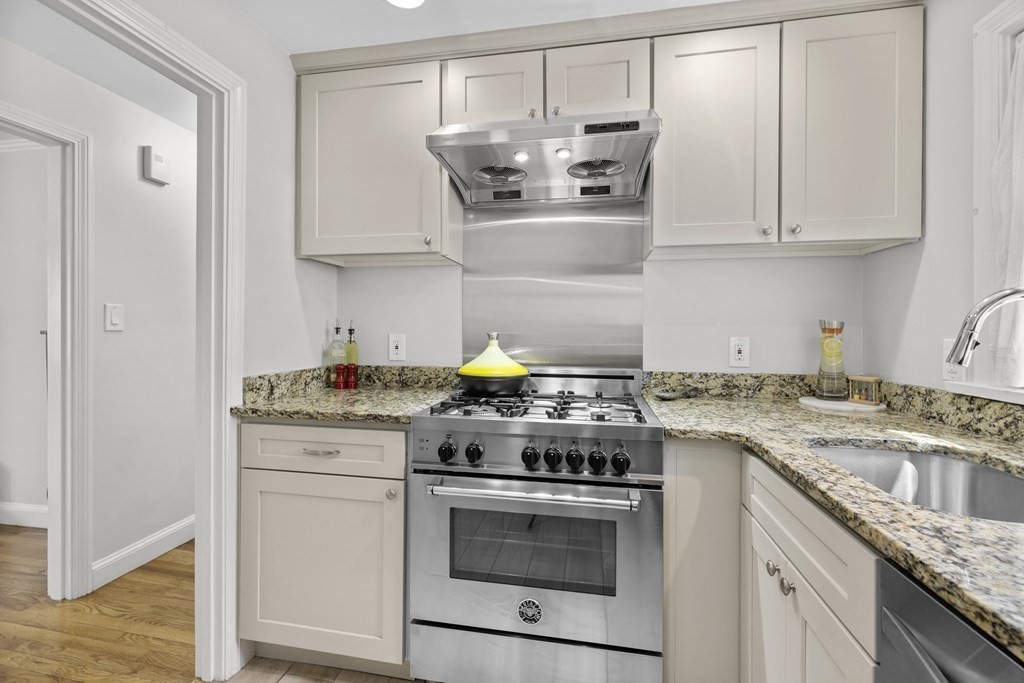 15 Dee Road Lexington, MA 02420 - Photo 4 of 34 a kitchen with stainless steel appliances granite countertop white cabinets and a stove