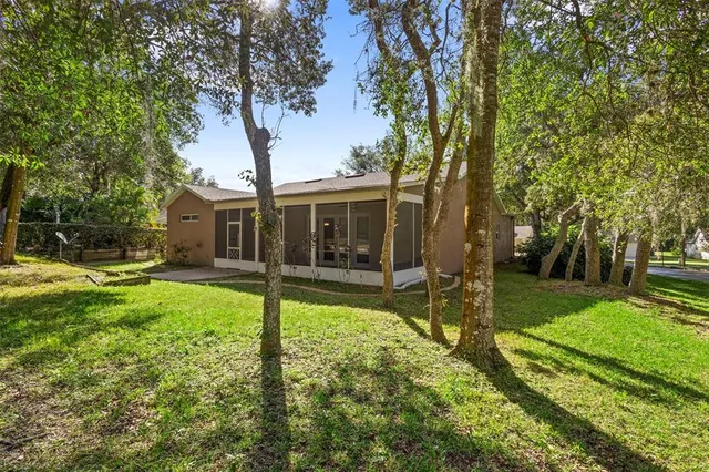 a view of a house with backyard and a tree