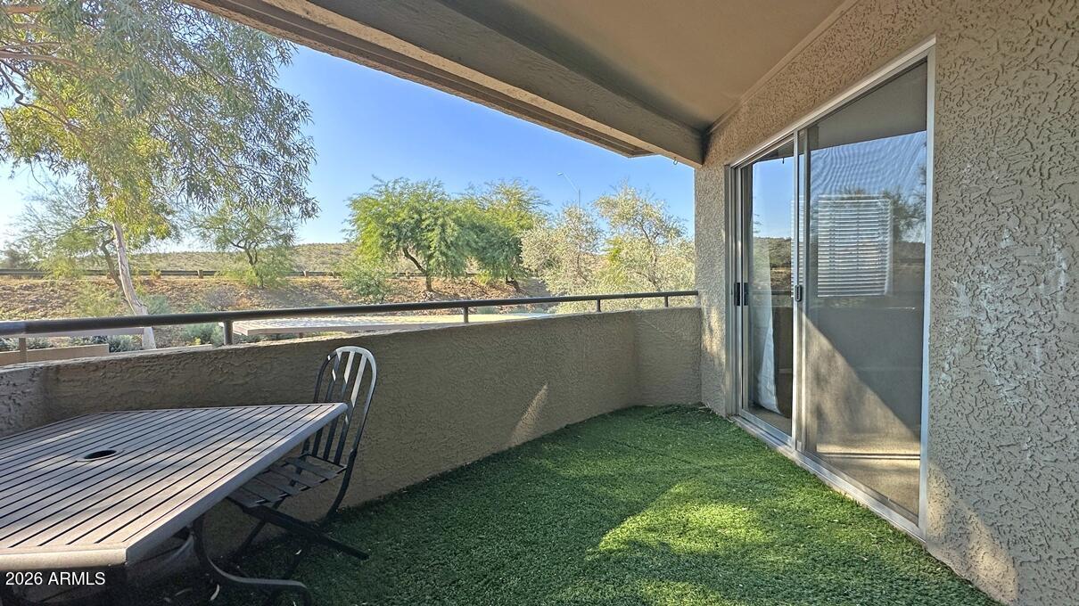 a view of a balcony with furniture and a yard